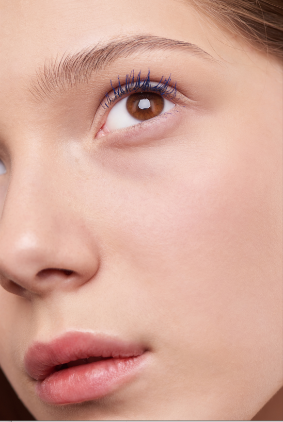 a woman applying on the blue mascara