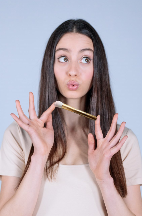 a woman holding a make up brush